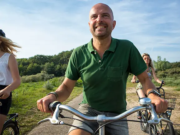 Gezin fietst in de duinen