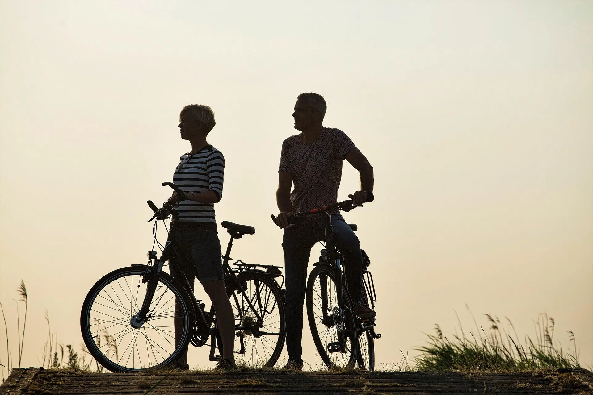 Mann und Frau auf einem Fahrrad an einer Brücke