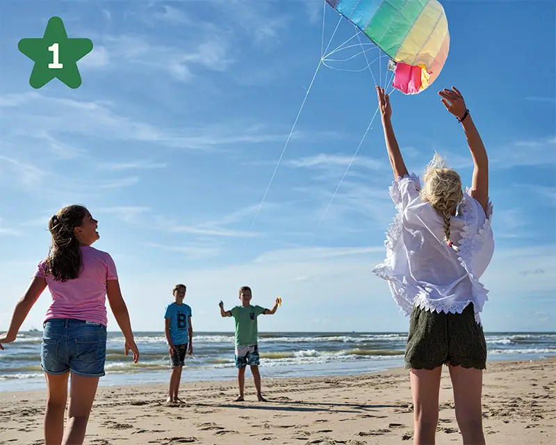 Jongens en meiden spelen op het strand