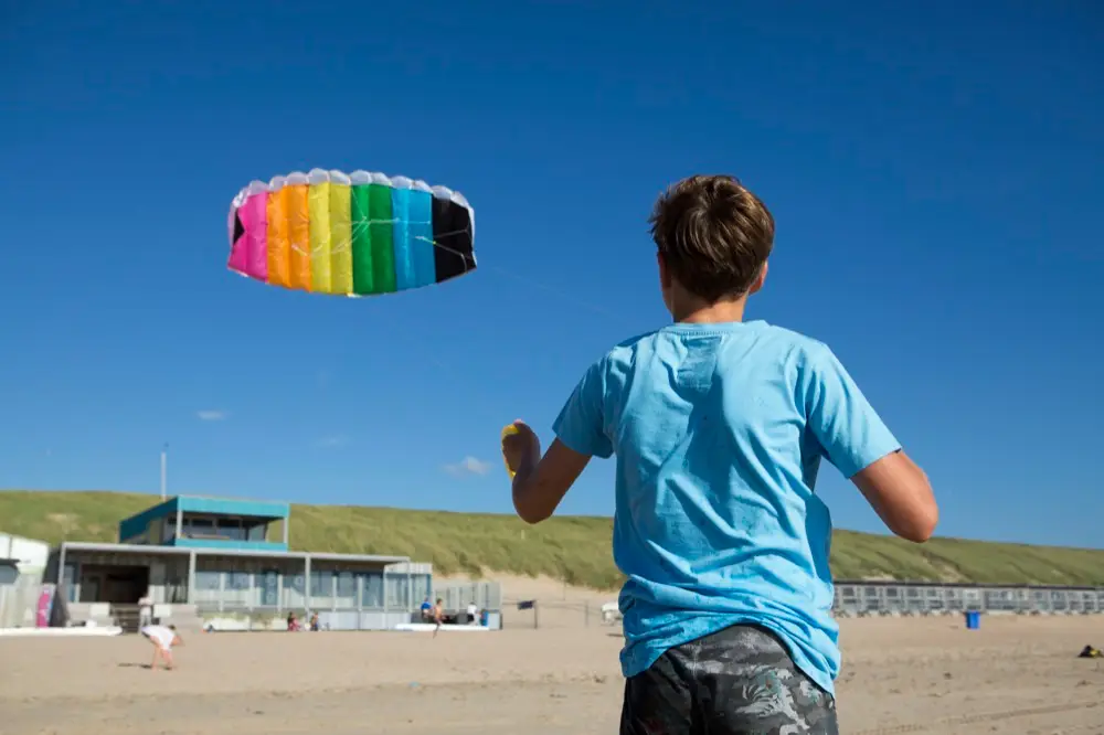 Kind aan het vliegeren op het strand