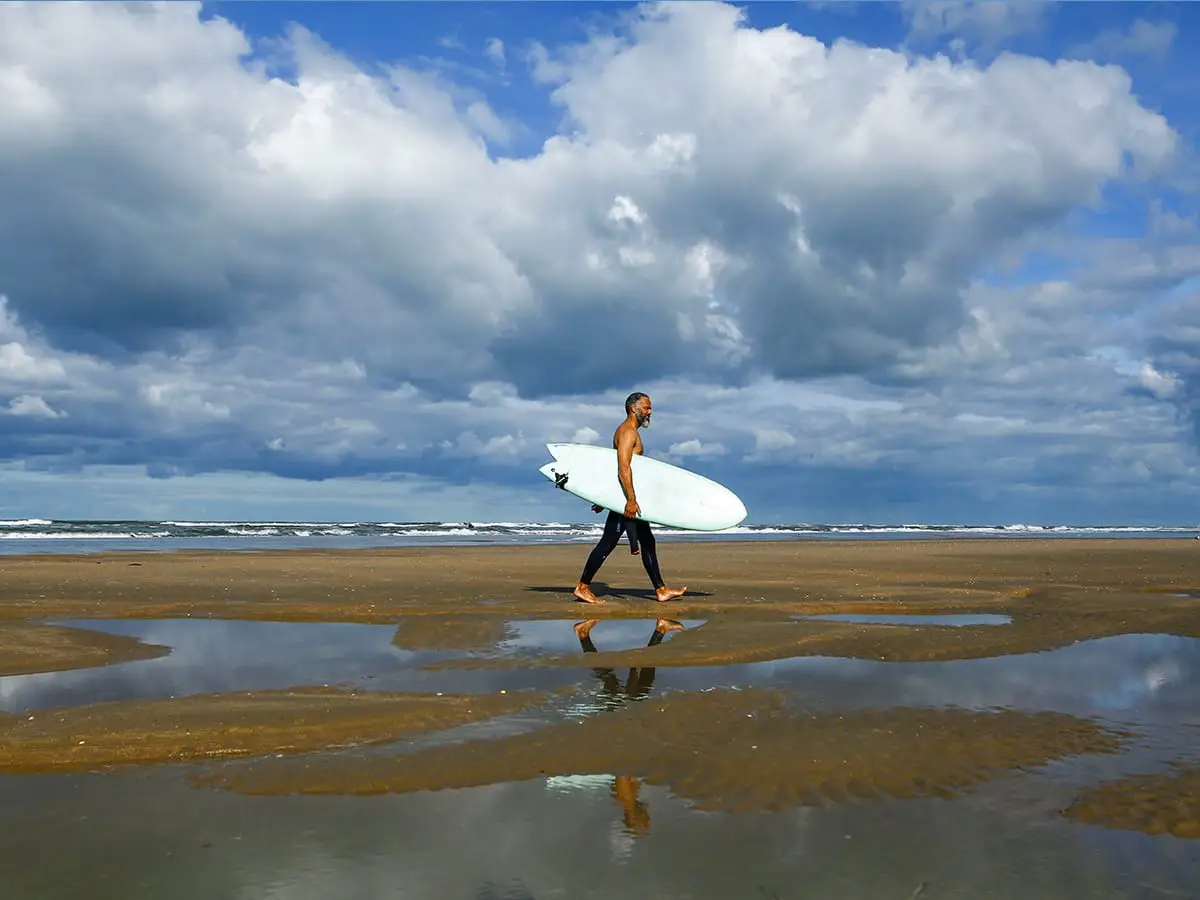 Surfer geht am Strand spazieren