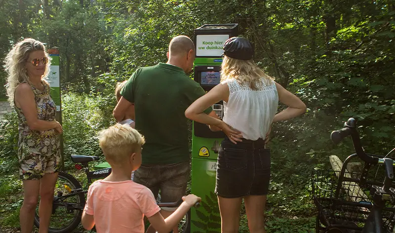 Een familie bij één van de duinkaartautomaten
