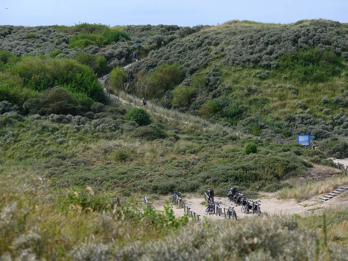 De fietsenstalling en het pad omhoog richting de duinen