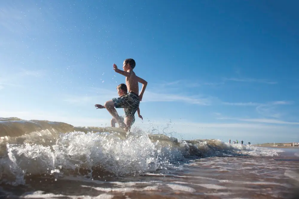 Jongens rennen de zee in