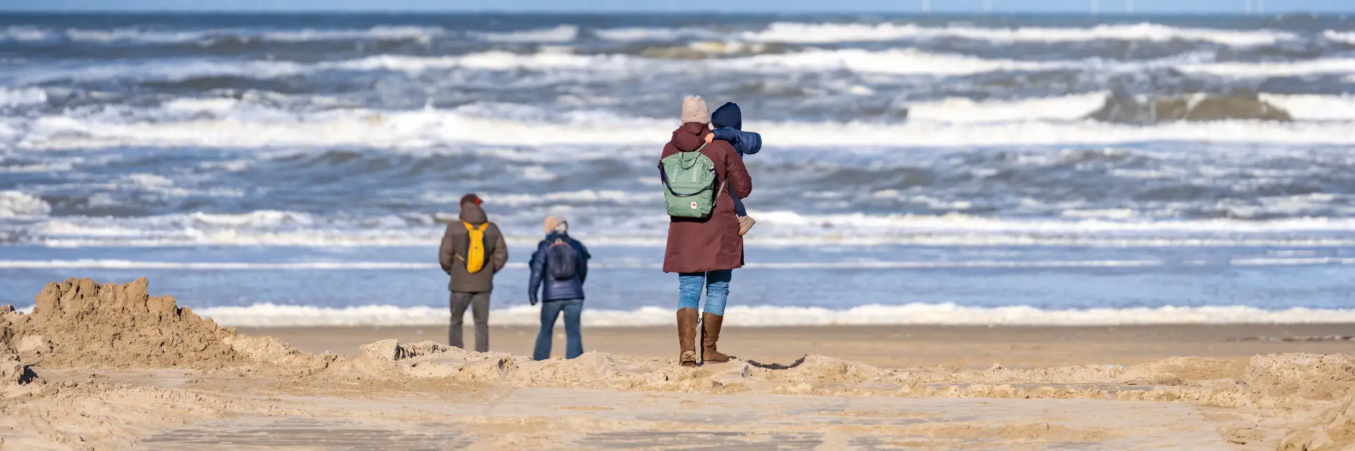 Moeder met kinderen lopen naar de zee