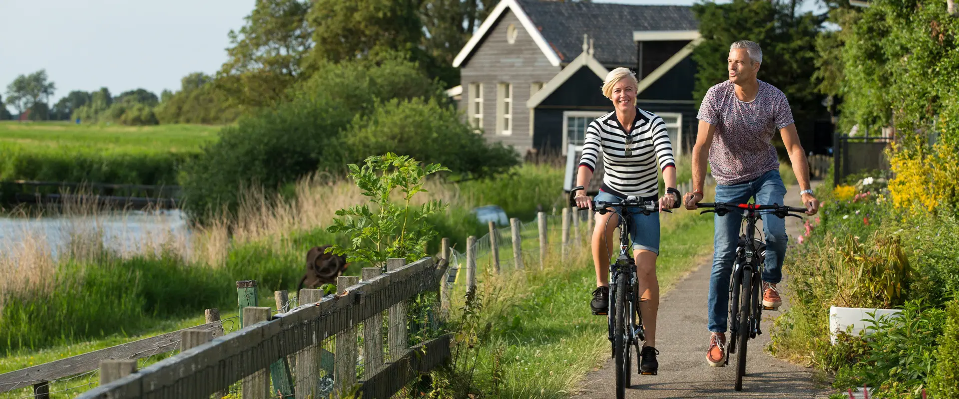 Man en vrouw fietsen langs het water