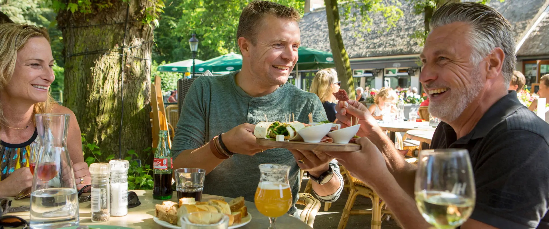 Vrouw aan tafel met twee mannen