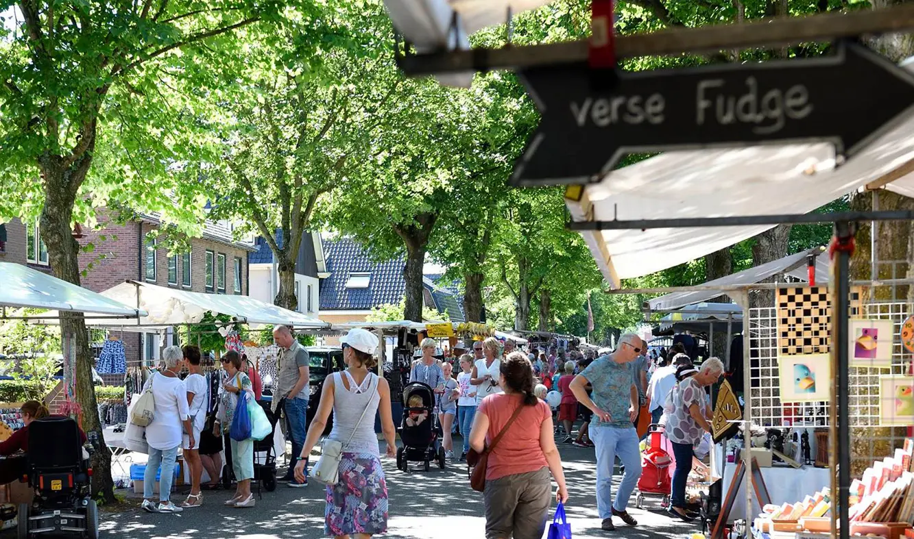 Mensen lopen langs kramen tijden de jaarmarkt in Limmen