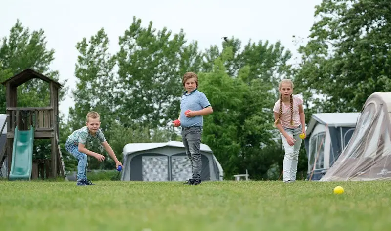 Drie kinderen aan het spelen op een boerencamping
