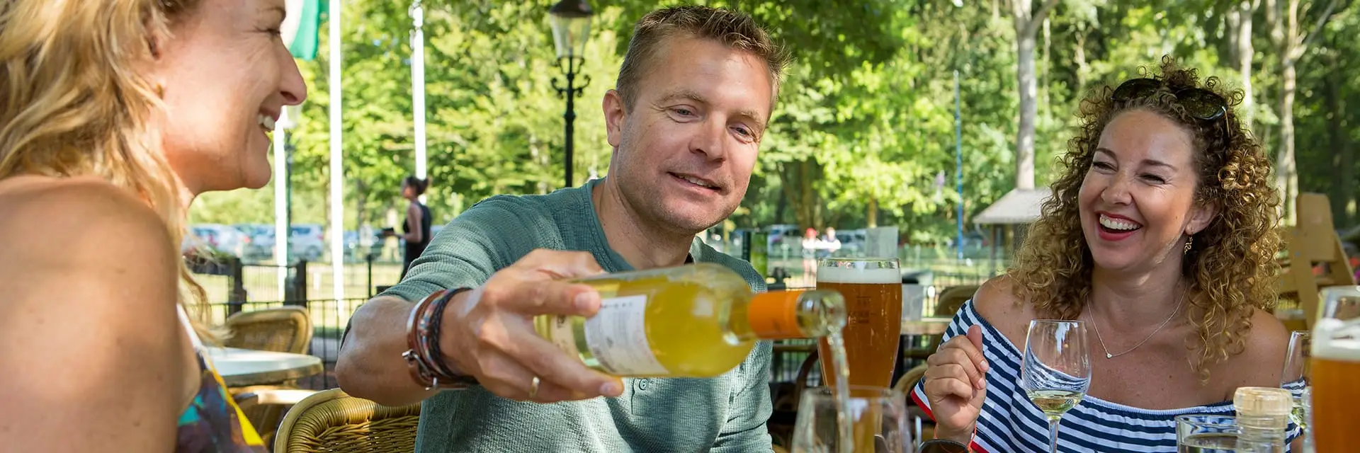 Die Gruppe sitzt auf der Terrasse und genießt eine Mahlzeit und Getränke