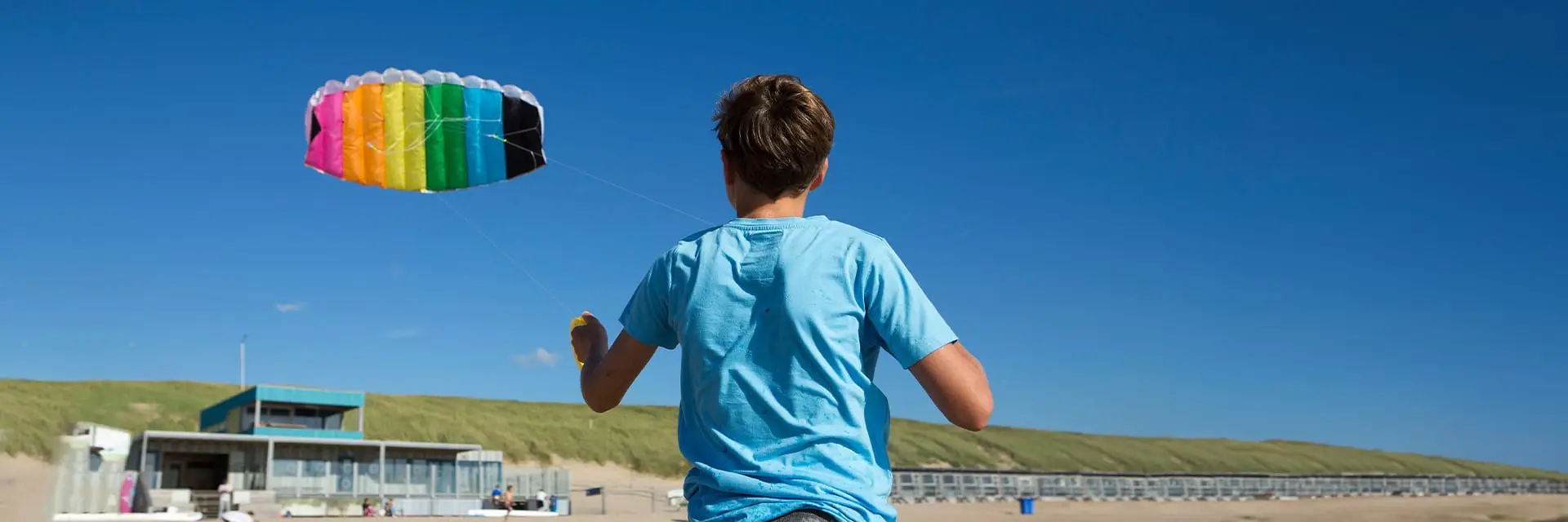 Jongen op het strand met een vlieger