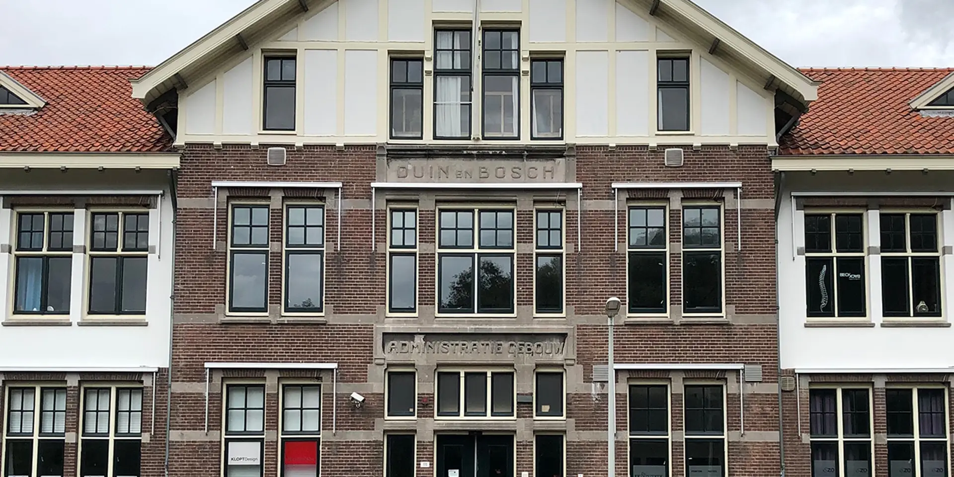 Twee wandelaars in de duinen die naar de kwal kijken