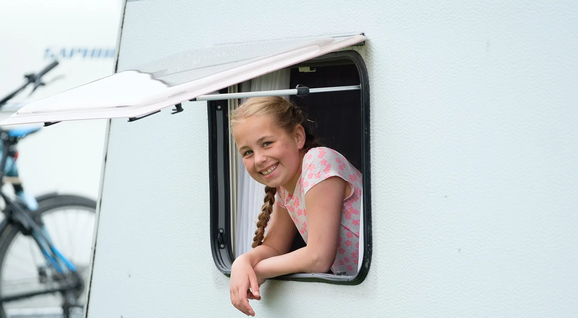 Meisje steekt hoofd uit Caravan