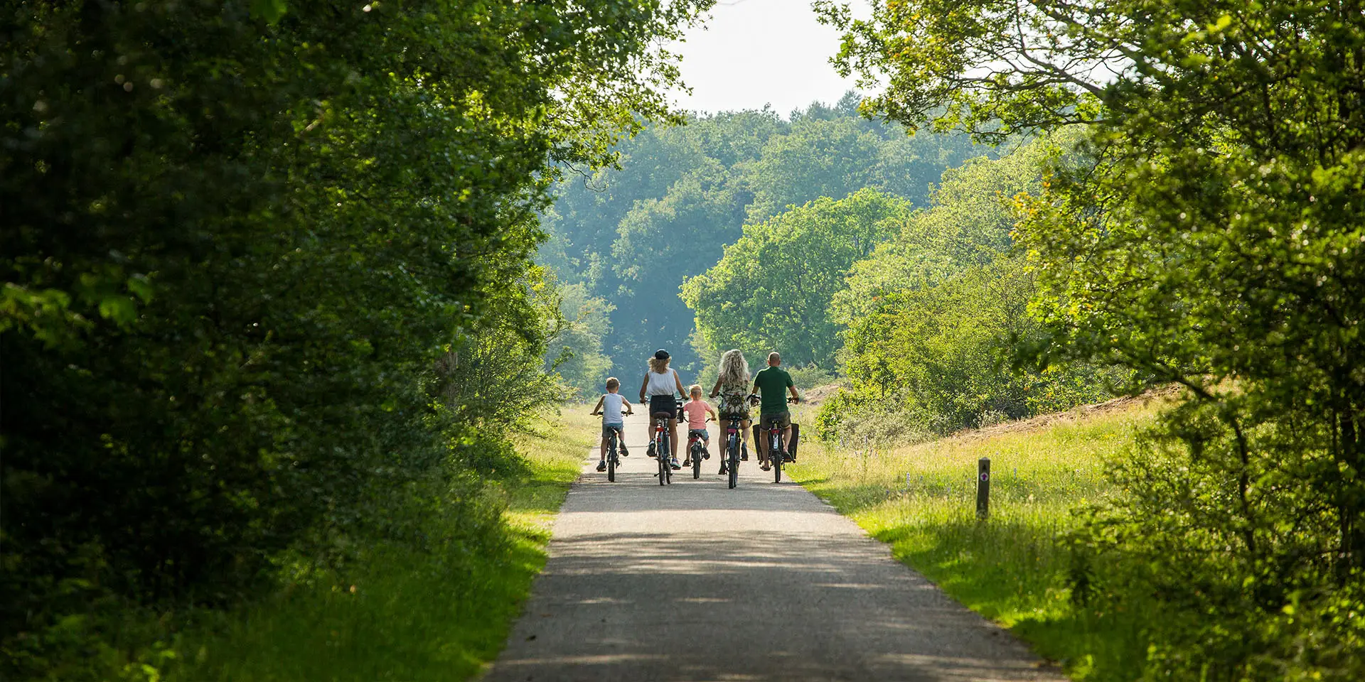 Fietsend gezin in de duinen