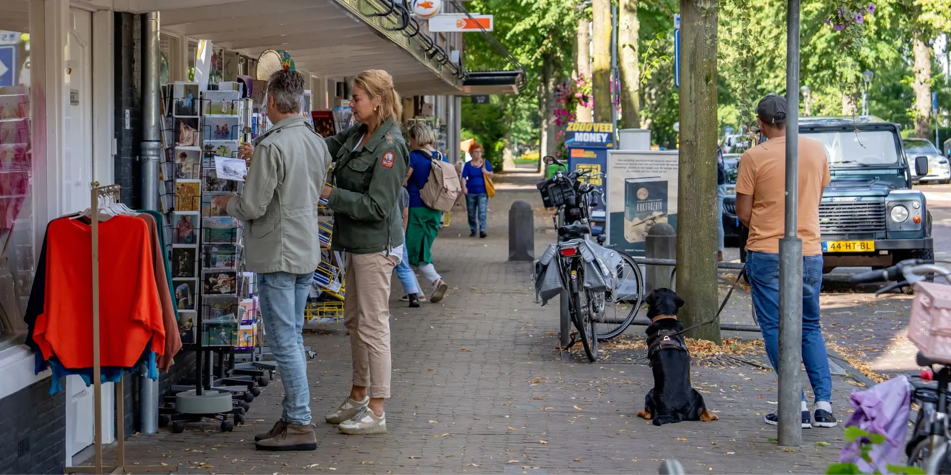 Een stel aan het kijken naar kaarten in een kaartenrek buiten de winkel