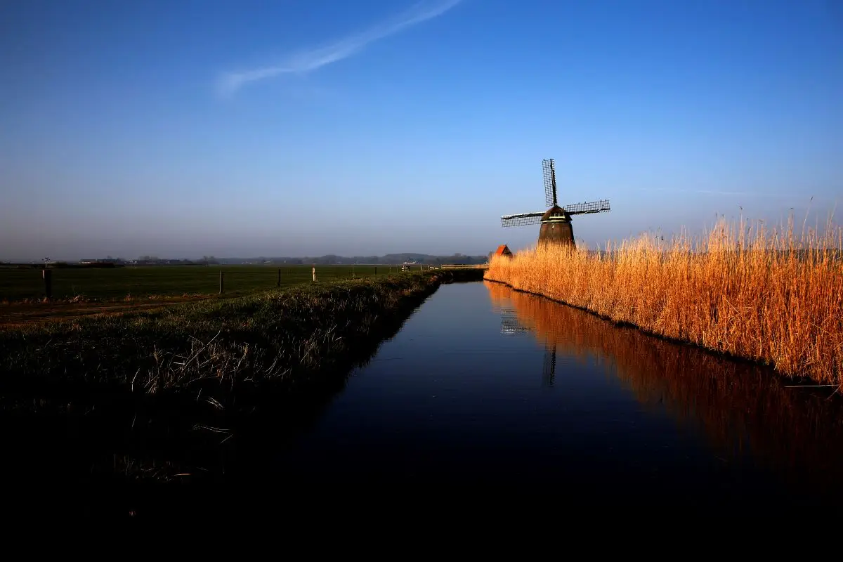 Graben mit Windmühle im Hintergrund