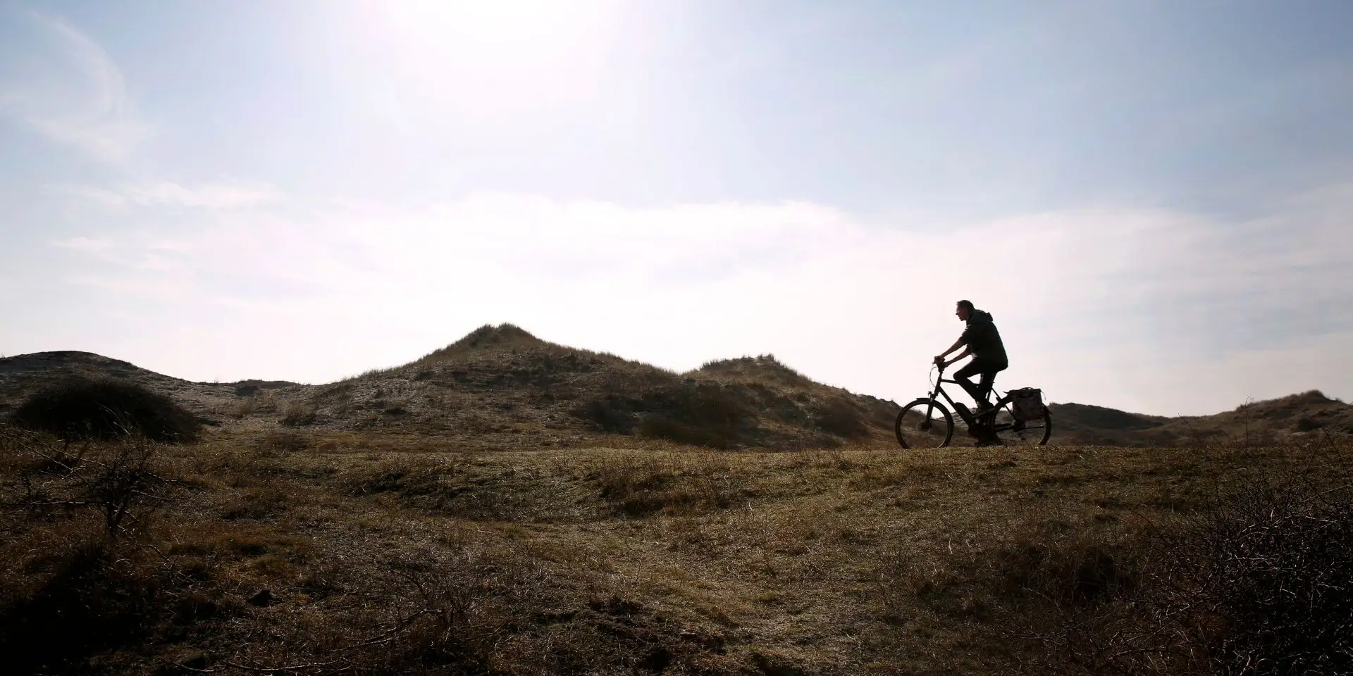 Fietser op fietspad met achtergrond van de duinen
