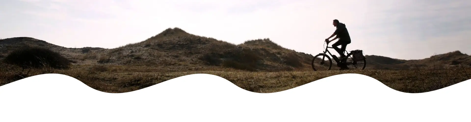 Radfahrer auf einem Radweg durch die Dünen