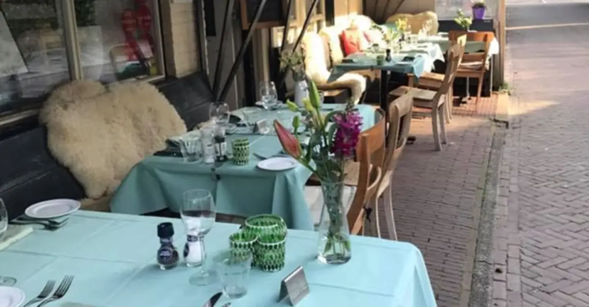 Sfeerimpressie van restaurant De Ware Jacob met gedekte tafeltjes met blauw tafelkleed en servies