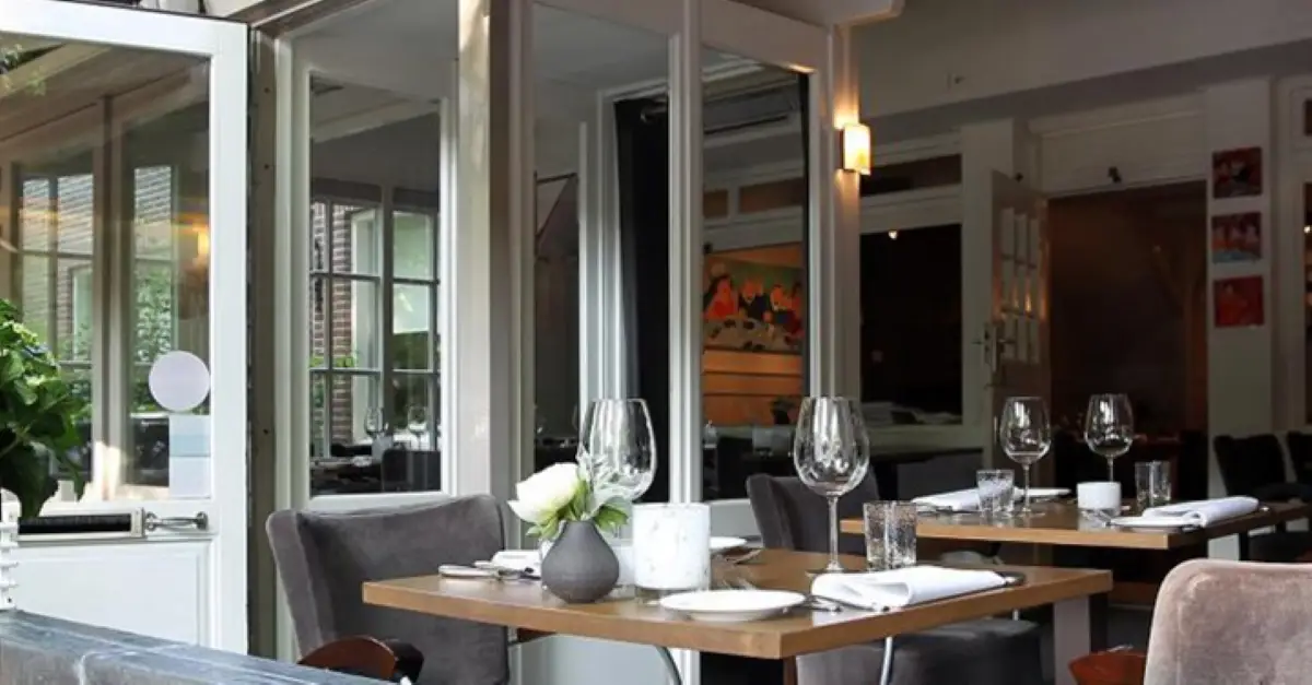 Sfeerimpressie van restaurant Onder de Linde met een gedekte tafel met wijnglazen