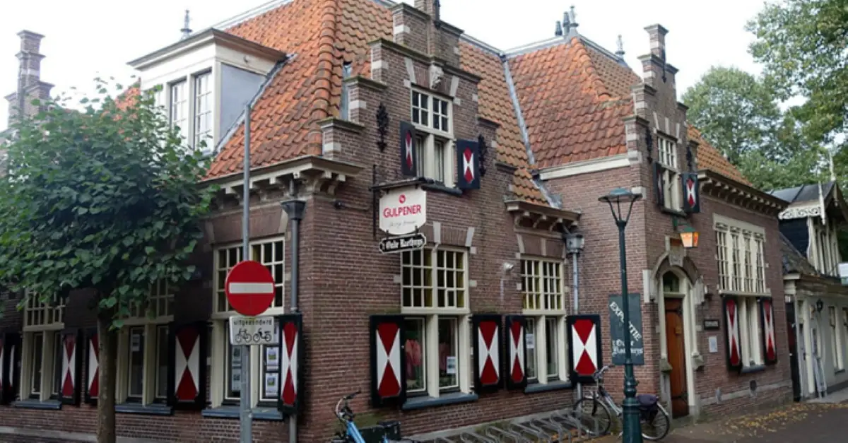 Vooraanzicht van 't Oude Reathuys, een mooi oud raadhuis met rood, witte geruite kozijnen en ramen met een trapgevel