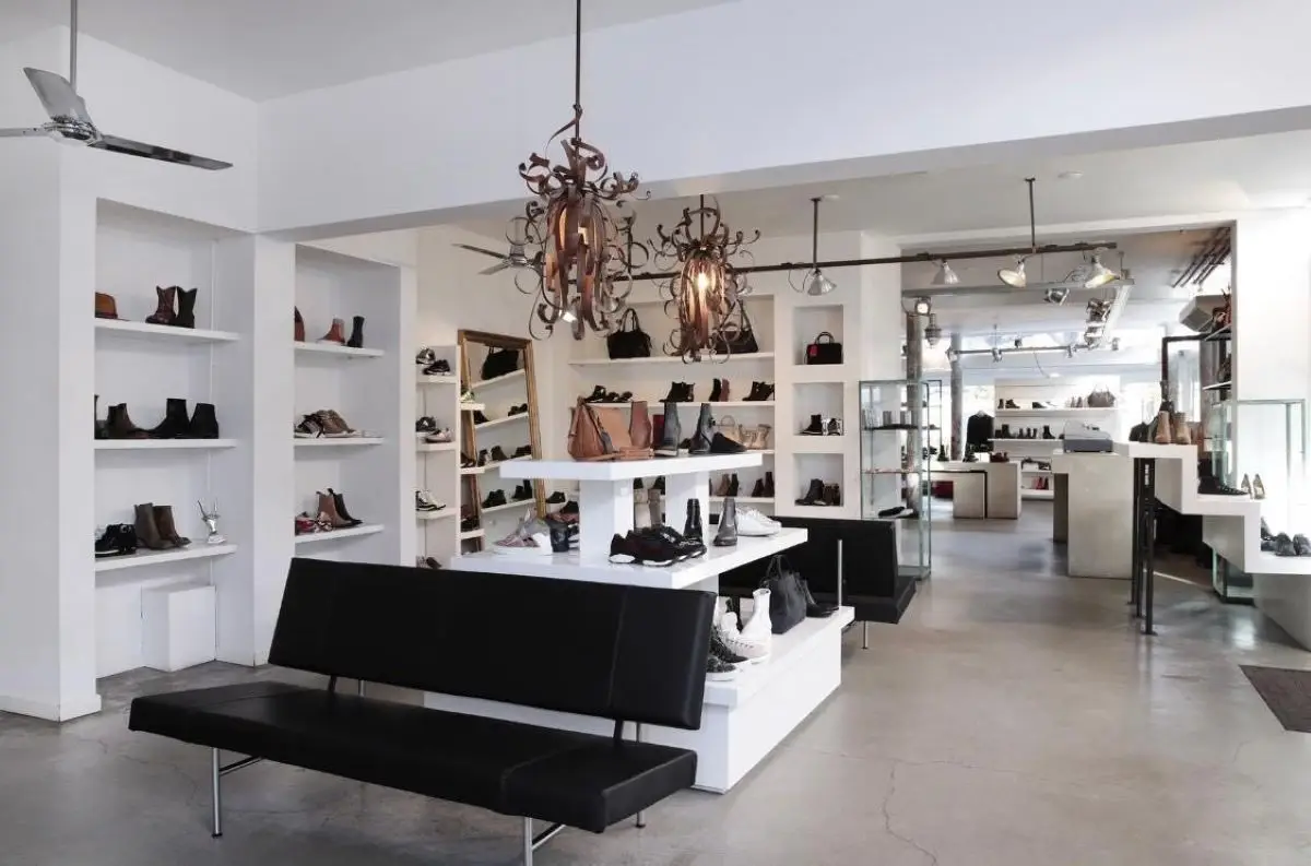 binnen in de winkel Shoebox met veel schoenen en een bank