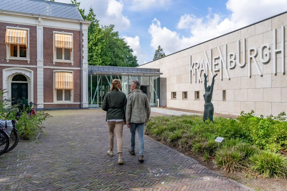 Wandelende mensen bij de ingang van Museum Kranenburgh