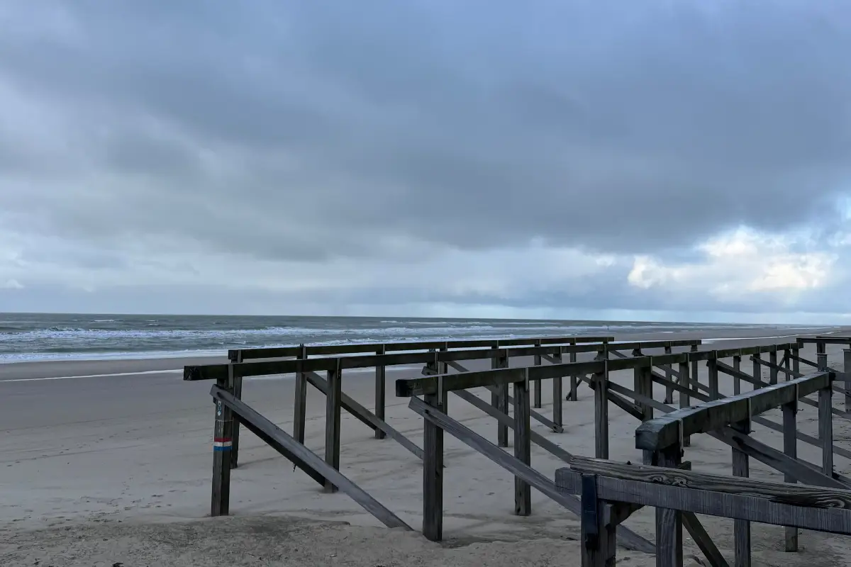 strand met houten palen en woeste zee en donkere lucht