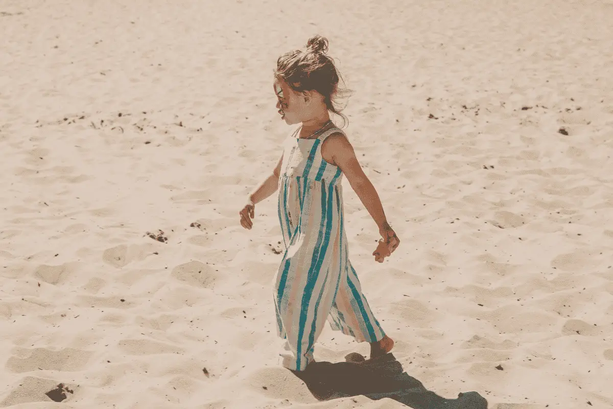 Kind in de Speelkuil → Een kind speelt en rent in de grote zandvlakte van de Speelkuil in Schoorl.