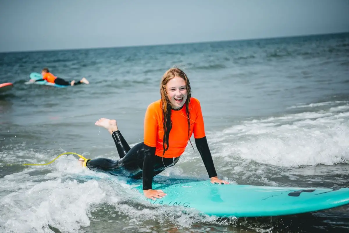 meisje lachend op surfbord