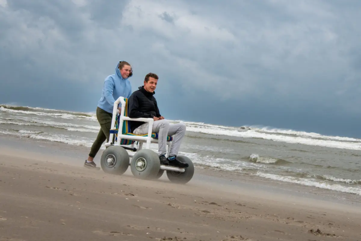 mensen op het strand met rolstoel