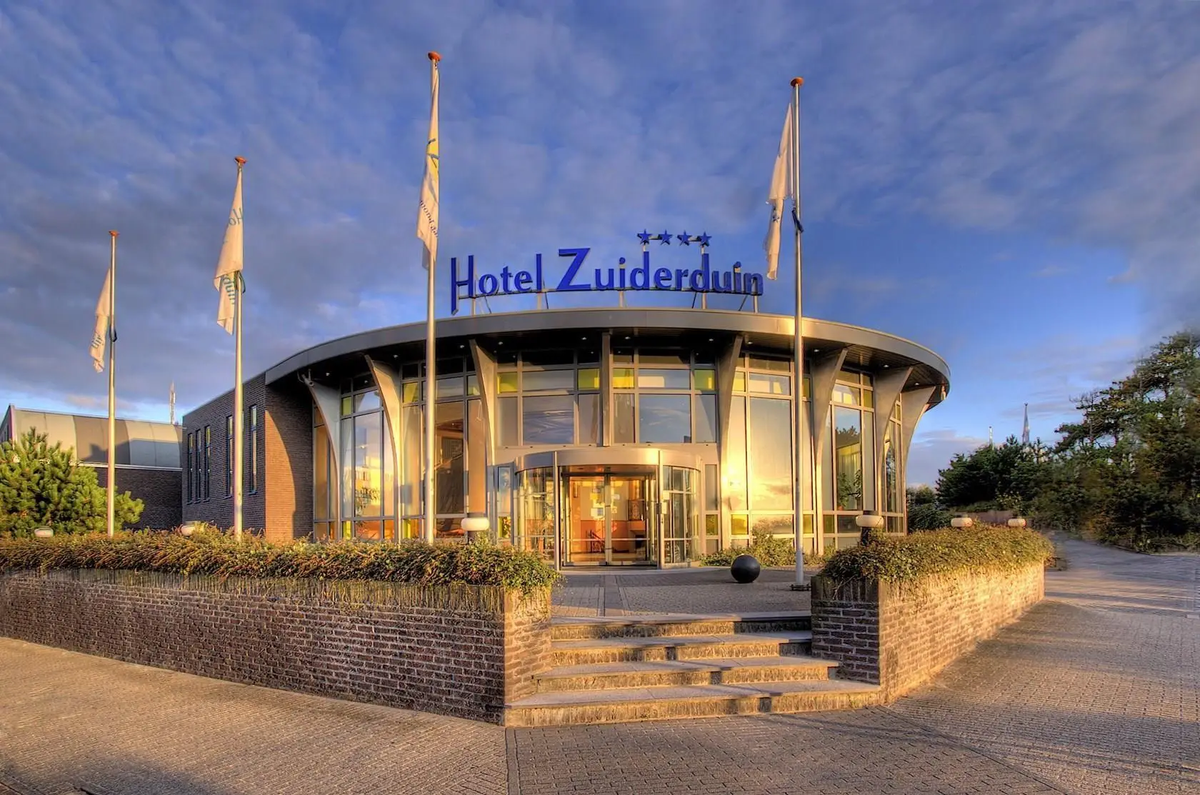 Hotel Zuiderduin van de voorkant met vlaggenmasten