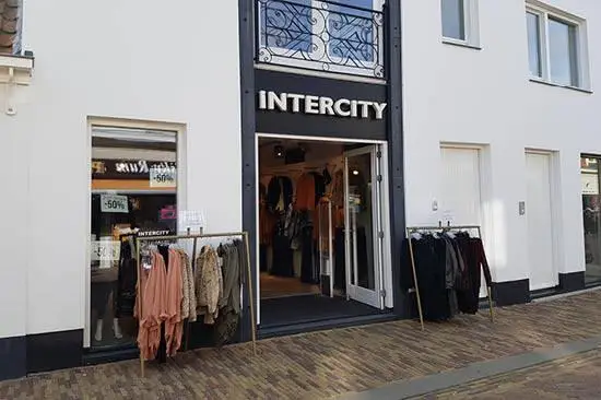 de buitenkant van de winkel van Intercity met kledingrekken die buiten staan