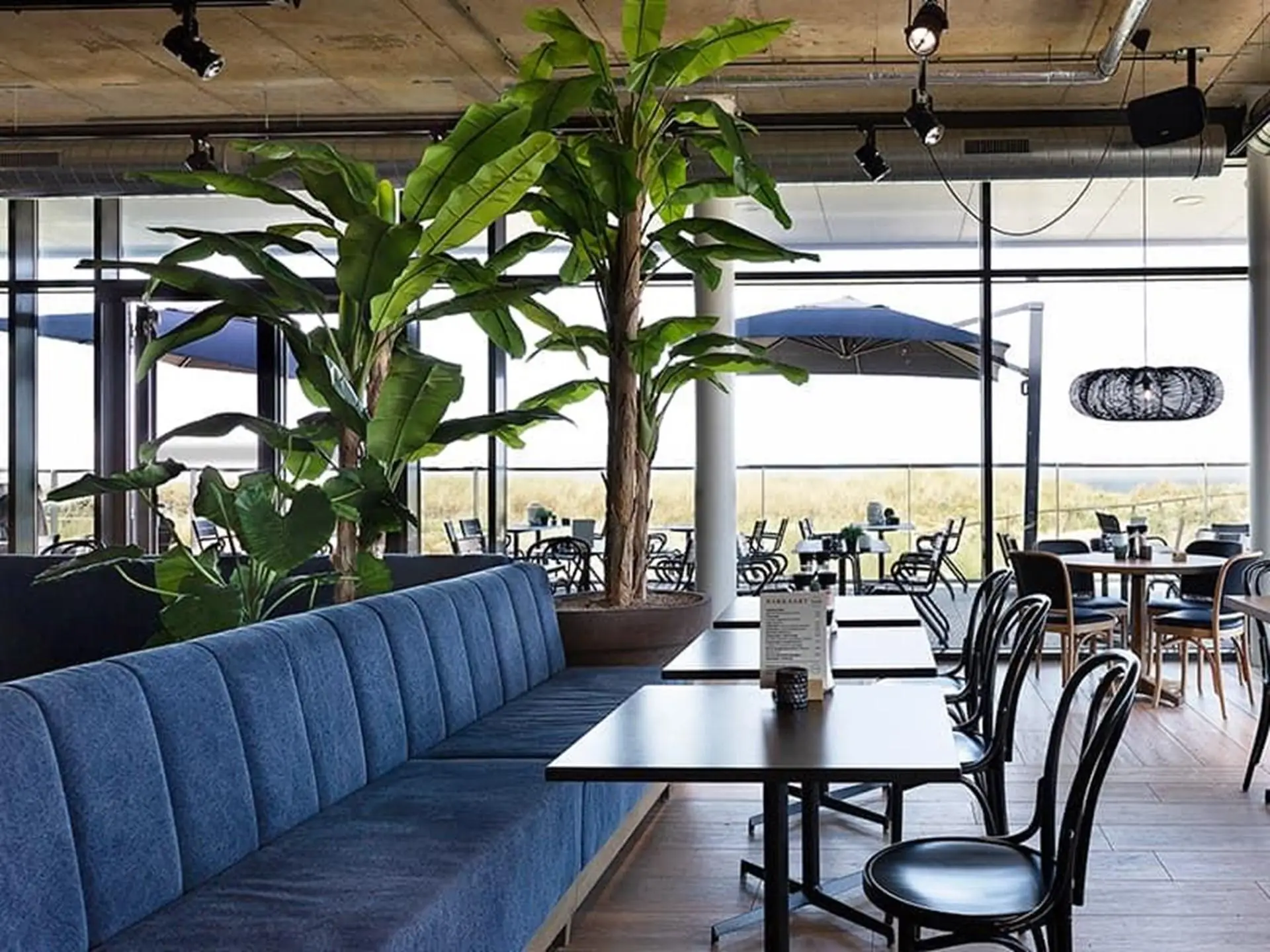 De binnenkant van het restaurant Comer met tafels, stoelen en banken