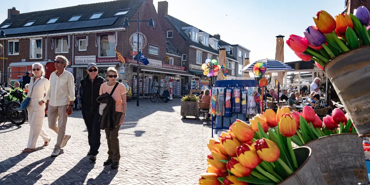 Wandelende mensen in de winkelstraat van Egmond aan Zee in de Voorstraat