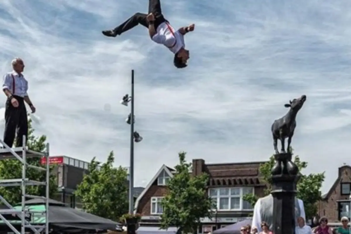 Artiesten die salto's maken tijdens een voorstelling op de zomerbraderie