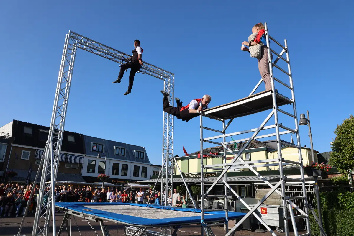 Artiesten die salto's maken tijdens een voorstelling op de zomerbraderie
