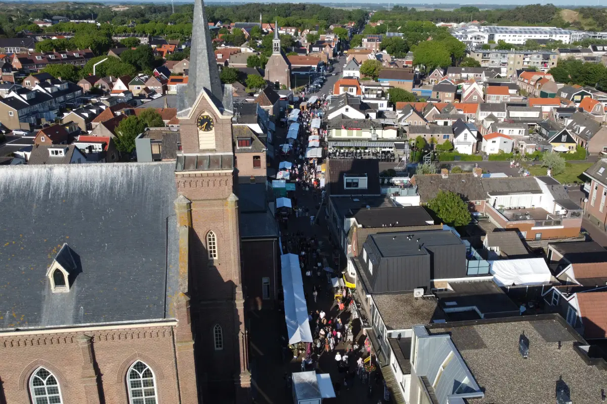 Overzichtsfoto van boven van de Voorstrata in Egmond met marktkramen en de Kerk