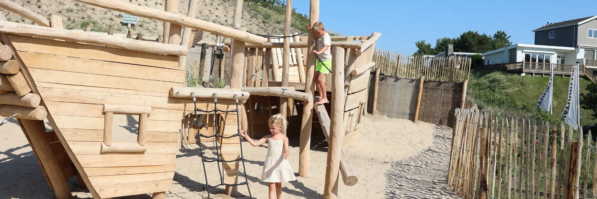 Zwei Kinder spielen mit den Wellen am Strand von Egmond aan Zee