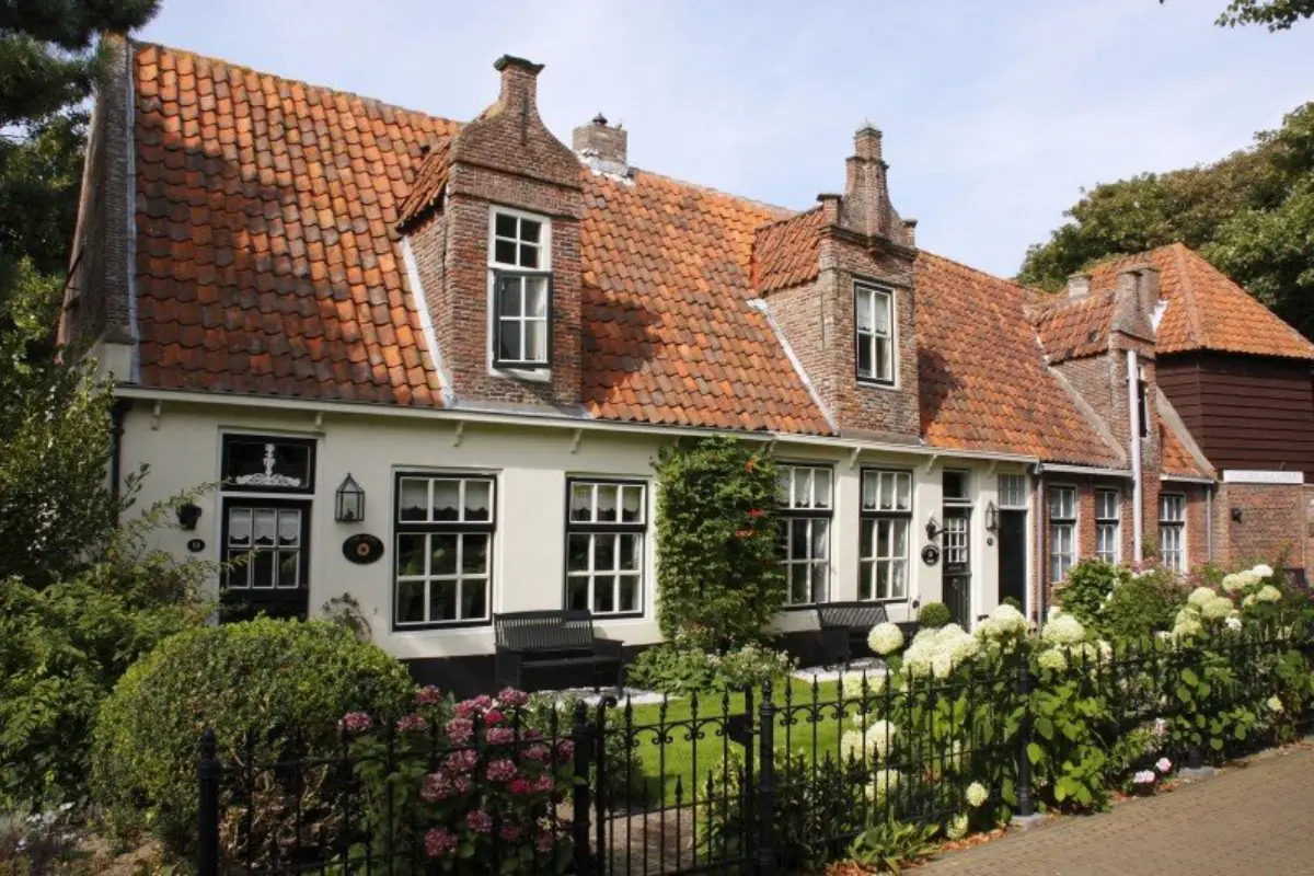 Galerie De Kapberg met naastgelegen zeventiende-eeuwse armenhuisjes in Egmond aan den Hoef