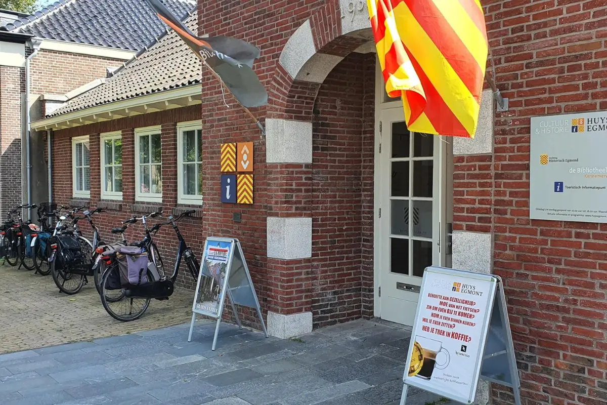 Foto van het vooraanzicht van bezoekerscentrum Huys Egmont met Egmondse geel-rode accenten en trapgevel