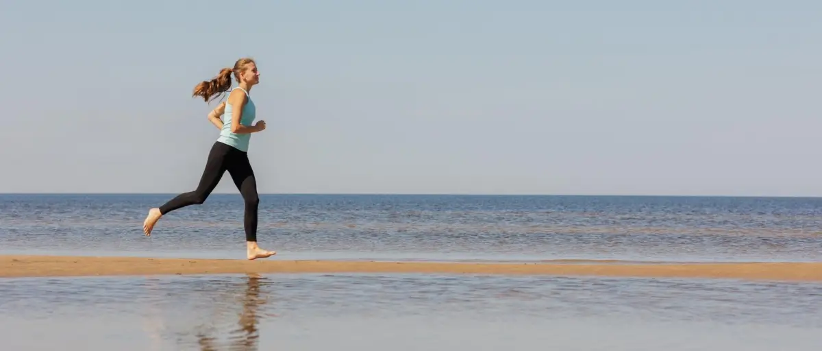Junge Frau läuft am Strand
