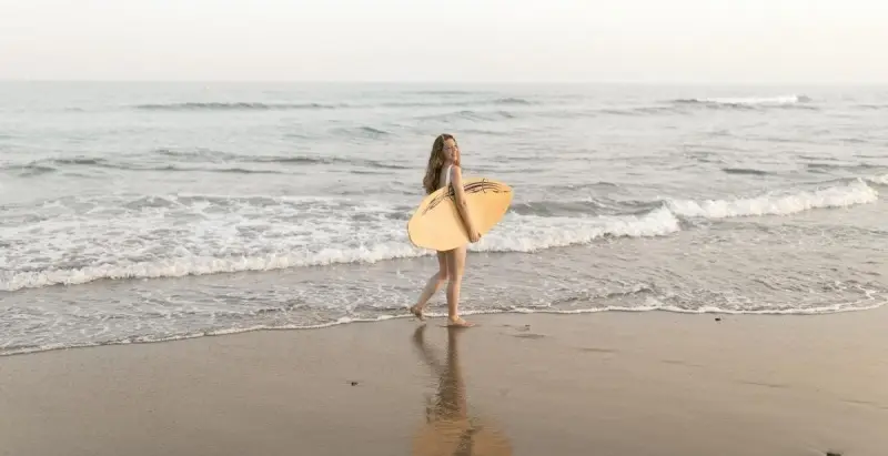 surfer met surfboard op het strand