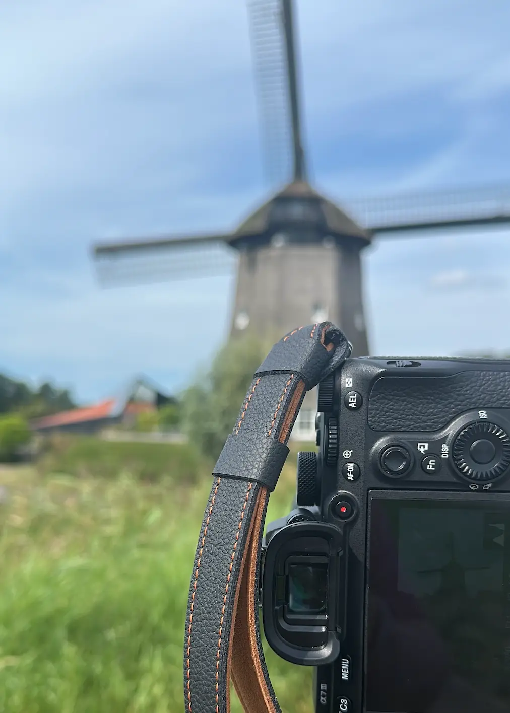 Een fotocamera op de voorgrond met daarachter de Twuyvermolen