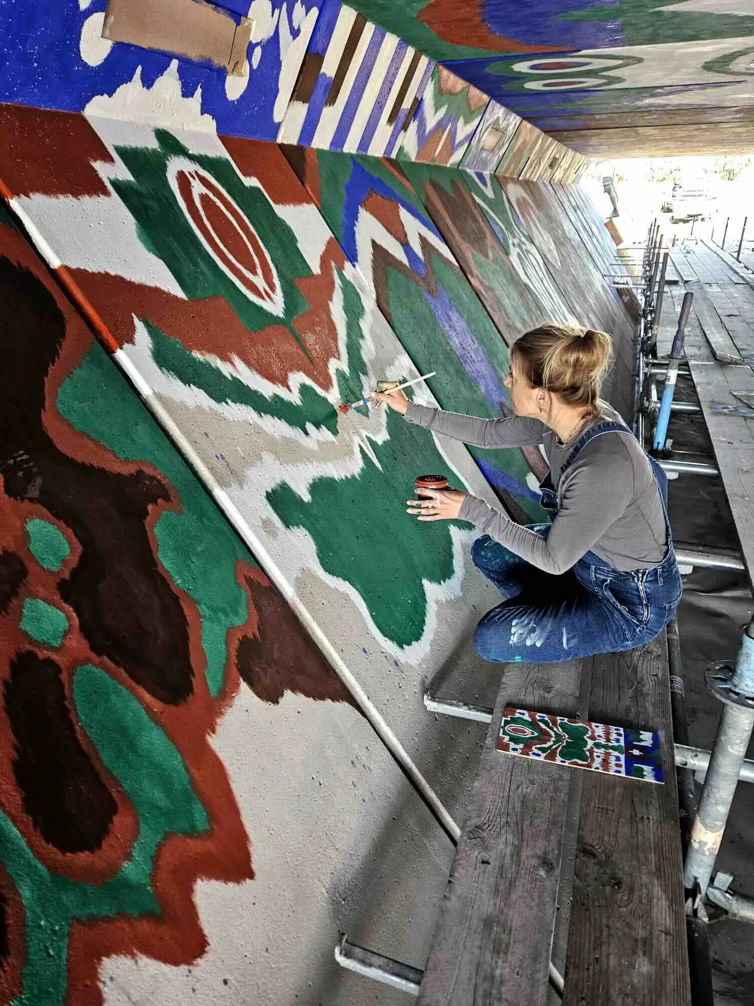 Kunstenaar is bezig met het beschilderen van de tunnel