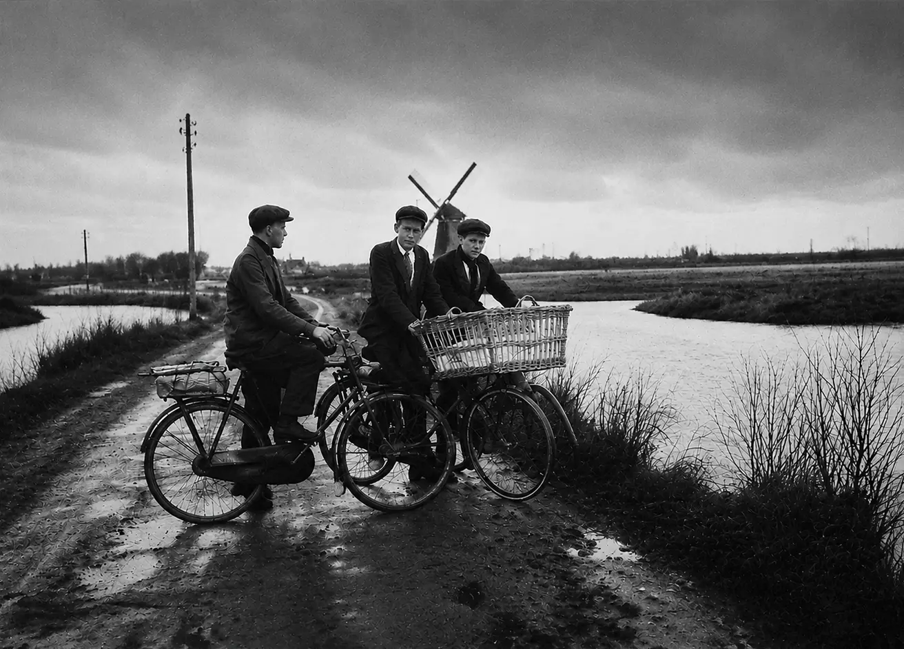 Geschiedenisfoto van de Twuyvermolen met drie jongens ervoor op de fiets