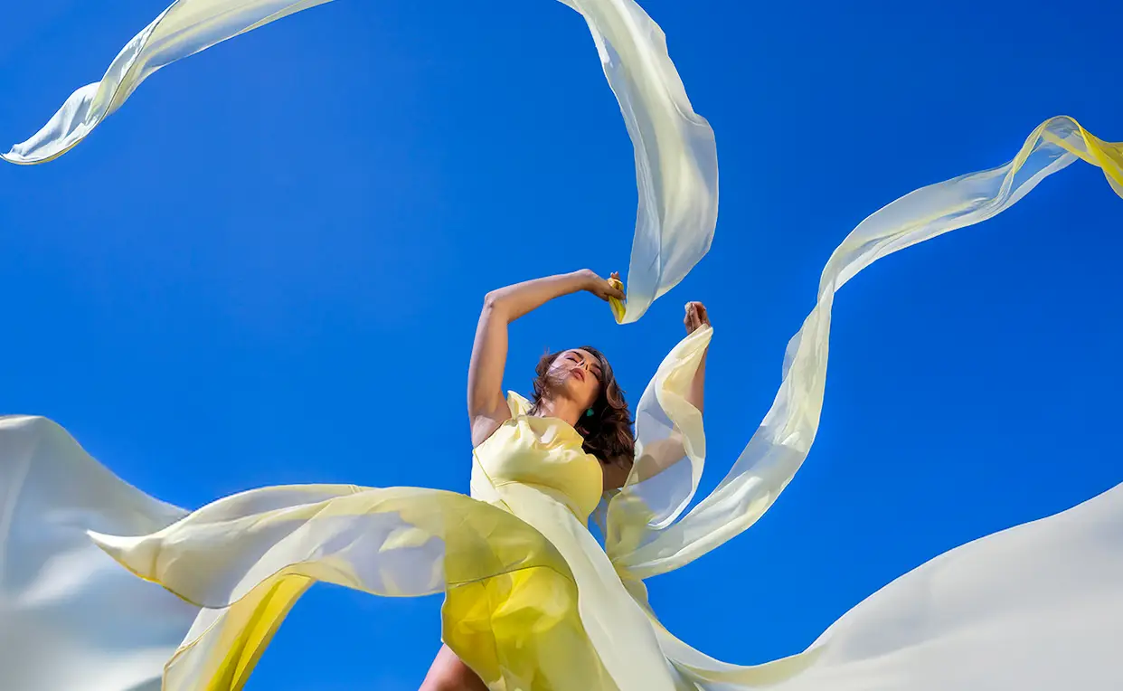 Vrouw met gele jurk en slingers