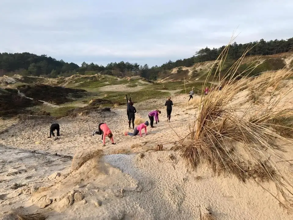 mensen aan het sporten in de duinen