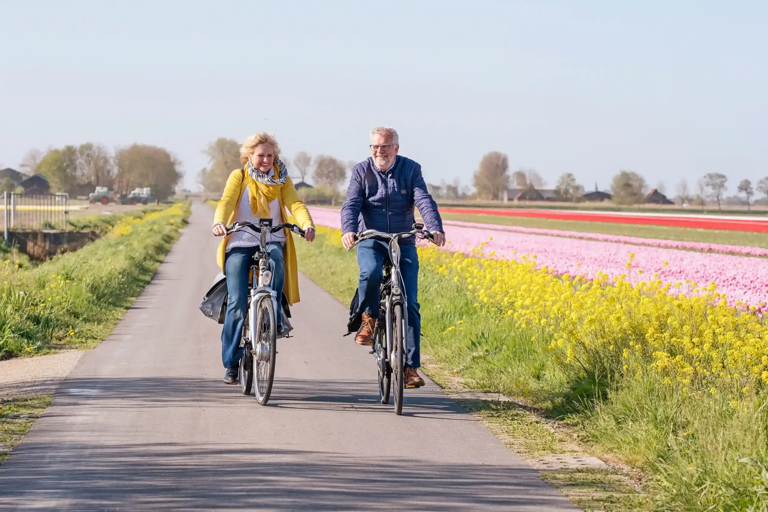 Man en vrouw fietsen in de polder