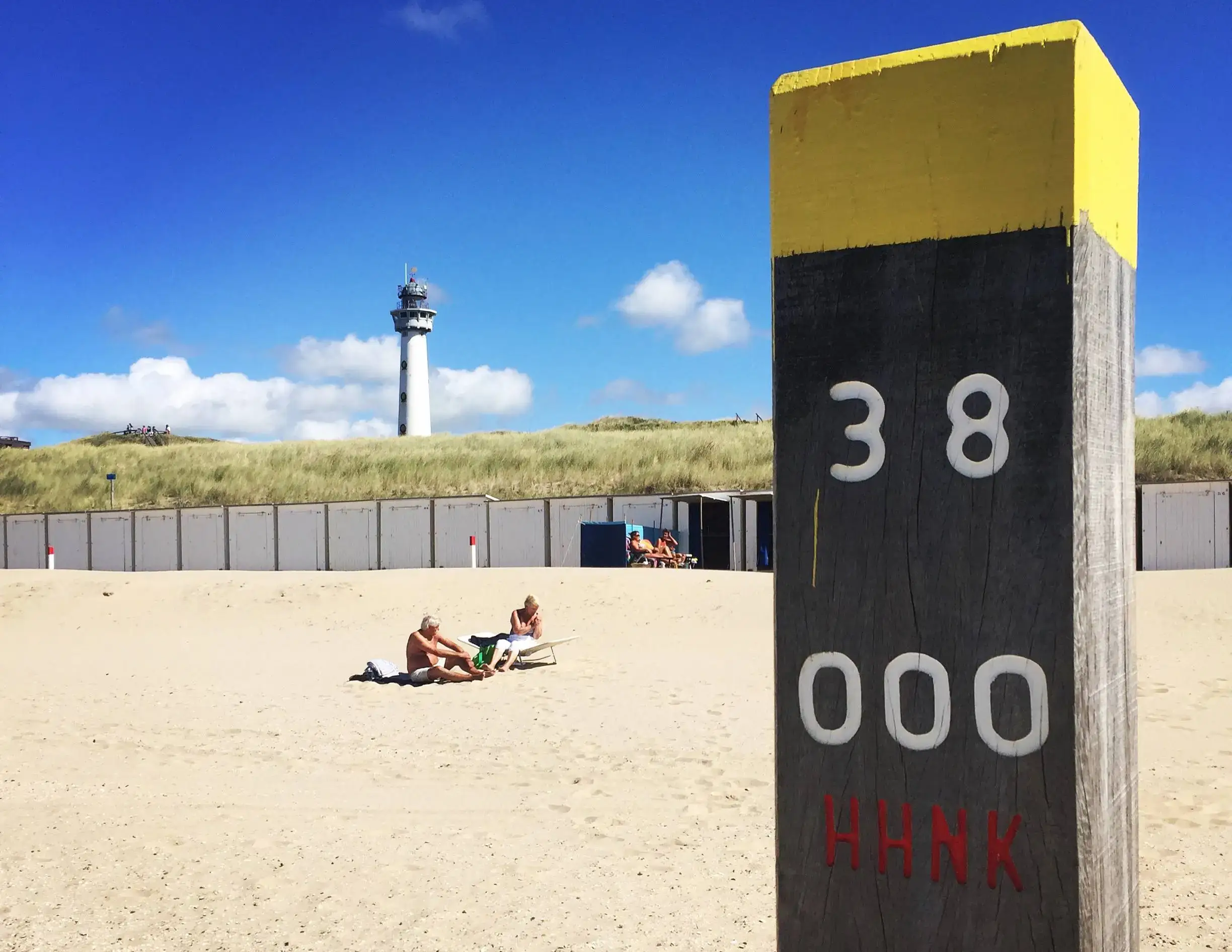Gele houten paal op het strand van Egmond